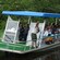 Una embarcación llena de personas y un guía turístico con un letrero que dice Eco Jungle Cruises